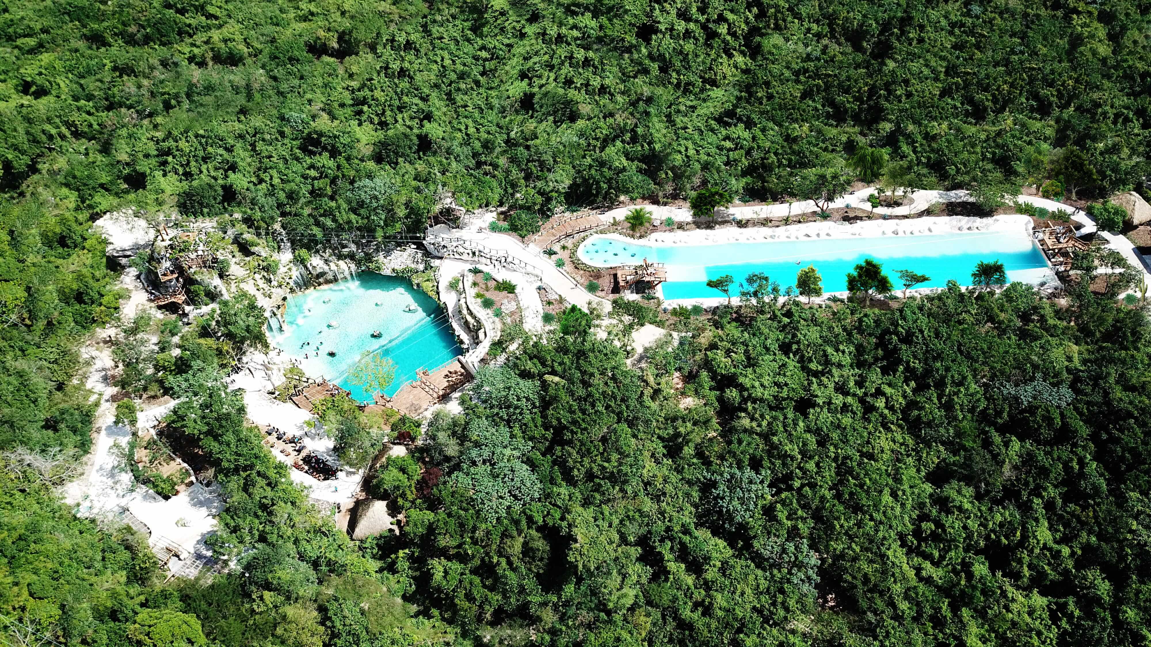 Tourists exploring the stunning blue water cenote at Scape Park